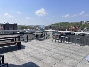 a patio with tables and chairs on a roof at Parlor - Explore OTR and DT from Restored 1894 Italianate in Cincinnati