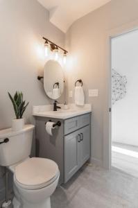 a bathroom with a toilet and a sink and a mirror at Parlor - Explore OTR and DT from Restored 1894 Italianate in Cincinnati