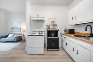 a white kitchen with a sink and a stove at Cozy 1BR with Parking - Near UC, Zoo, Downtown in Cincinnati