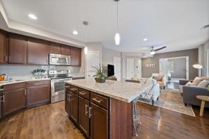 an open kitchen and living room with a counter top at Classy 2BR Condo Near City Centre - OTR, UC, Zoo in Cincinnati