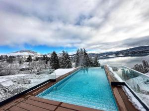uma piscina com vista para uma montanha coberta de neve em Hotel Roser House Boutique - pe malul lacului Colibita em Colibiţa