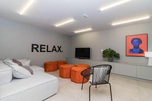 - un salon avec un canapé blanc et des fauteuils orange dans l'établissement Duque by My Way - a 100 metros da Santa Casa e UFRGS, à Porto Alegre