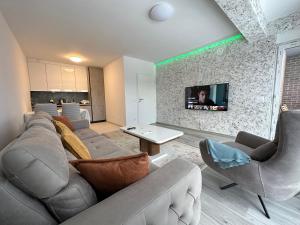 a living room with a couch and chairs and a tv at BesTer Apartment in Ferizaj