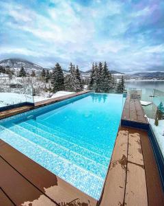 une grande piscine avec de la neige au sol dans l'établissement Hotel Roser House Boutique - pe malul lacului Colibita, à Colibiţa