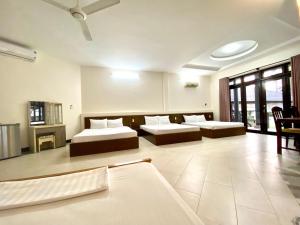 een grote kamer met 2 bedden en een bank bij Jaguar House Resort Muine in Mũi Né