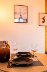 uma mesa com dois copos de vinho e um prato em Cocon CHALEUREUX aux portes de PARIS em Ivry-sur-Seine