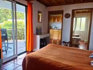 1 dormitorio con cama de color naranja y balcón en StoneWood Lodge AL en São Vicente Ferreira