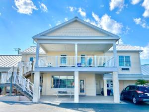 a large white house with a porch and a balcony at Island Inn of Atlantic Beach in Atlantic Beach