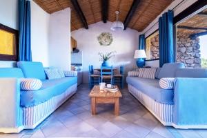 a living room with blue couches and a table at Residence I Cormorani Bis in Baja Sardinia