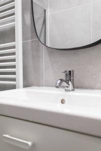 - białą umywalkę z lustrem w obiekcie Cocon CHALEUREUX aux portes de PARIS w mieście Ivry-sur-Seine