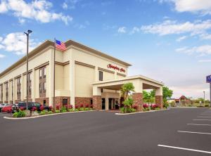 Timber PinesHampton Inn by Hilton Spring Hill的停车场内悬挂美国国旗的酒店