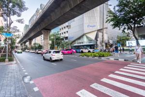 una calle de la ciudad con coches estacionados al costado de la carretera en A4 Cosy Twin large beds - Silom en Bangkok