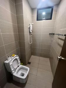 a bathroom with a toilet and a shower with a phone at Rex-apartment 3room near new Kpj Saradise Bdc in Kuching +5 photos