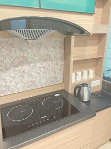 a kitchen with a stove top oven in a kitchen at Rex-apartment 3room near new Kpj Saradise Bdc in Kuching