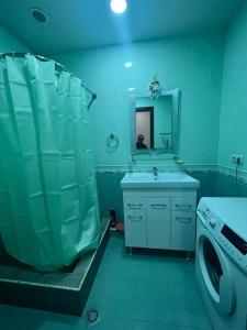 a bathroom with a shower and a sink and a washing machine at Byuzand 7 in Yerevan
