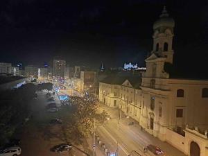 a large building with a clock tower at night at Central Getaway studio in Bratislava