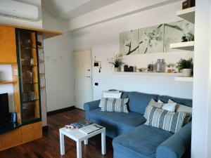 a living room with a blue couch and a table at Mansarda DaSy in Ancona