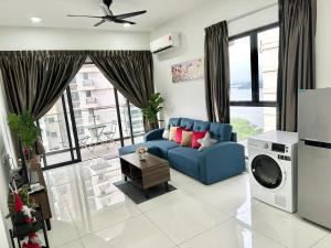 uma sala de estar com um sofá azul e uma televisão em Sand Resort @ Country Garden Danga Bay em Johor Bahru