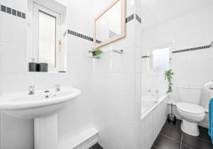 a white bathroom with a sink and a toilet at Nicol Apartment by Klass Living Airdrie in Airdrie