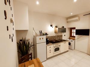 uma cozinha com armários brancos e um forno com placa de fogão em Sicula Liz & Lulù em Palermo