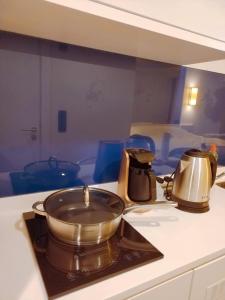 a pot on a stove top with a tea kettle at Orbi City apartment with sea view in Batumi
