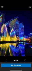 a view of a city at night with a fountain at Orbi City apartment with sea view in Batumi