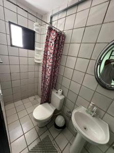 a bathroom with a toilet and a sink and a mirror at Dunas Hostel in Natal