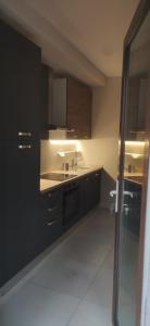 a kitchen with black cabinets and a sink at Loft Mag in Fanano