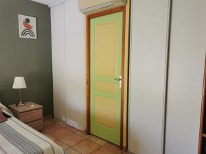 Un dormitorio con una puerta verde y una cama en Chambre spacieuse avec bureau et balcon, en Millas