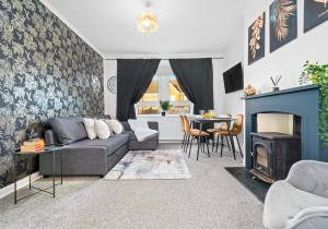 a living room with a couch and a fireplace at Uddingston Apartment by Klass Living in Uddingston