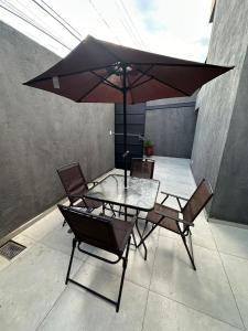 a table and chairs with an umbrella on a patio at Hotel Village in São Bernardo do Campo