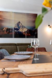 uma mesa de madeira com pratos e um copo de vinho em ARMONA em Brides-les-Bains