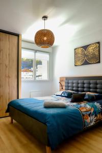 1 dormitorio con 1 cama grande y edredón azul en ARMONA, en Brides-les-Bains