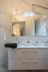 uma casa de banho com um lavatório branco e um espelho. em ARMONA em Brides-les-Bains