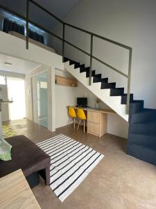 ein Wohnzimmer mit einer Treppe in einem Haus in der Unterkunft Lofts Umuarama Residence in Uberlândia