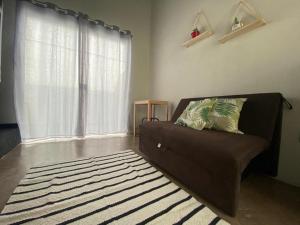 uma sala de estar com um sofá e uma grande janela em Lofts Umuarama Residence em Uberlândia