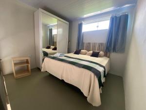 a bedroom with two beds and a large mirror at Lofts Umuarama Residence in Uberlândia