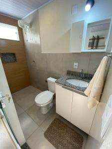 a bathroom with a toilet and a sink at Lofts Umuarama Residence in Uberlândia