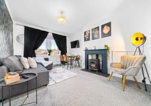 a living room with a couch and a fireplace at Uddingston Apartment by Klass Living in Uddingston