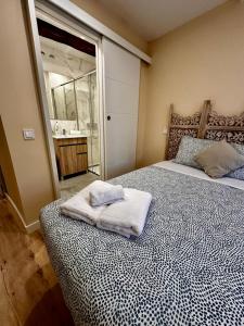een slaapkamer met een bed met handdoeken erop bij Atuaire Home Los Arcos en el centro histórico de Burgos in Burgos