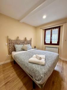 een slaapkamer met een bed met twee handdoeken erop bij Atuaire Home Los Arcos en el centro histórico de Burgos in Burgos