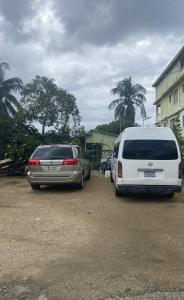 due auto parcheggiate in un parcheggio accanto a un edificio di Chaleanor Hotel a Dangriga