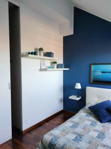 アンコーナにあるMansarda DaSyの青いアクセントの壁のベッドルーム1室、ベッド1台が備わります。