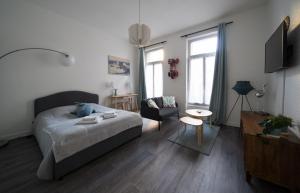 1 dormitorio con 1 cama y sala de estar en AppartUnique - Chez Murillo, en Vichy