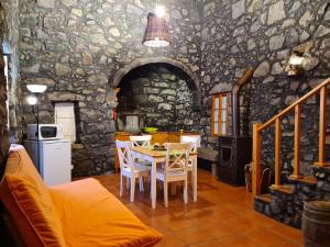 a kitchen and dining room with a table and chairs at StoneWood Lodge AL in São Vicente Ferreira