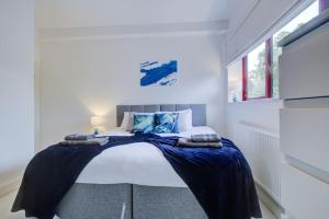 a bedroom with a bed with a blue blanket on it at Open Mind Property - City Centre & Free Parking for Unlimited Vehicles in Fareham