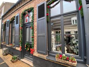 een winkel met kerstkransen op de ramen bij maison cosy et spa zen en Flandres et côte d'opale in Hondschoote