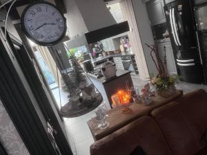 een woonkamer met een klok en een tafel met kaarsen bij maison cosy et spa zen en Flandres et côte d'opale in Hondschoote