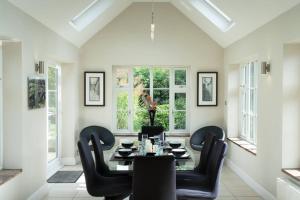 a dining room with a table and black chairs at Superb 4BD Stay in Wyton and Houghton Village in Wyton