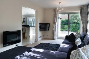 a living room with a couch and a tv at Superb 4BD Stay in Wyton and Houghton Village in Wyton
